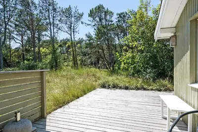 a wooden deck with a bench on the side of a house at 168-Thisted-Sandtornvej-8 in Thisted