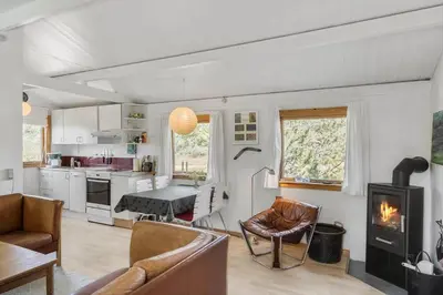 a living room with a fireplace and a kitchen at 168-Thisted-Sandtornvej-8 in Thisted