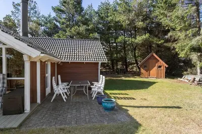 a backyard with a table and chairs and a shed at 876-Thisted-Klemsvej-27 in Thisted