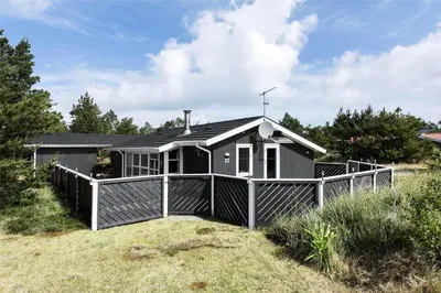 a small house with a fence in front of it at 705-Thisted-Klitrosevej-22 in Thisted