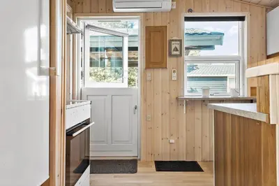 a small kitchen with a white door and windows at 705-Thisted-Klitrosevej-22 in Thisted
