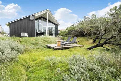 a group of chairs sitting in the grass in front of a house at 897-Thisted-Nordsovej-46-C in Thisted