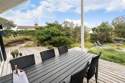 a wooden table and chairs on a deck with a view at 897-Thisted-Nordsovej-46-C in Thisted