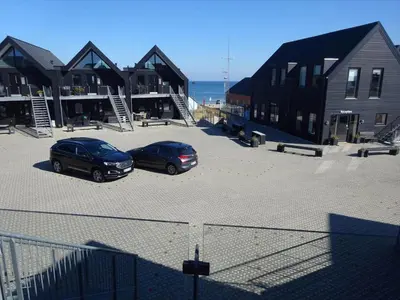 two cars parked in a parking lot next to houses at 794-Thisted-Havstokken-26-1 in Thisted