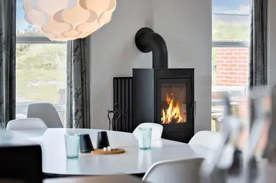 a dining room with a table and a fireplace at 150-Thisted-Orredvej-32 in Thisted