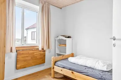 a small bedroom with a bed and a window at 1017-Thisted-Hvidbakken-17 in Torsted