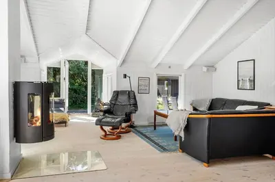 a living room with a bed and a fireplace at 1013-Thisted-Sine-Krokones-Vej-12 in Torsted