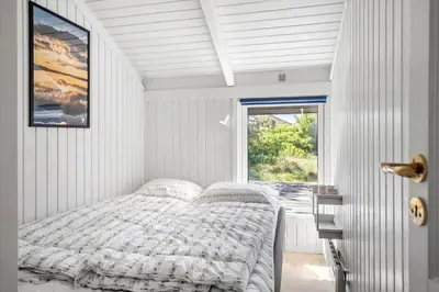 a white bedroom with a bed and a window at 1013-Thisted-Sine-Krokones-Vej-12 in Torsted