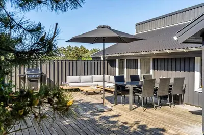 a patio with an umbrella and a table and chairs at 1013-Thisted-Sine-Krokones-Vej-12 in Torsted