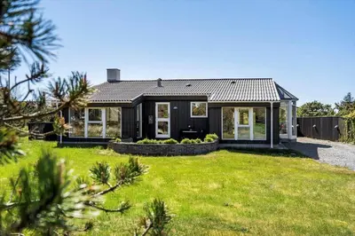 a black house with a green yard at 1013-Thisted-Sine-Krokones-Vej-12 in Torsted