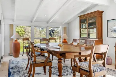 a dining room with a wooden table and chairs at 1013-Thisted-Sine-Krokones-Vej-12 in Torsted