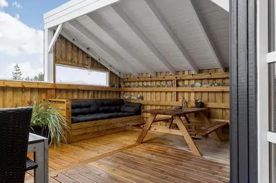 a wooden patio with a table and a bench at 990-Thisted-Spanggardsvej-29 in Torsted