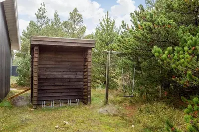 a small wooden shed in a yard with trees at 990-Thisted-Spanggardsvej-29 in Torsted