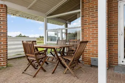 a wooden table and chairs on a patio at 273-Snedsted-Sarasvej-33 in Snedsted