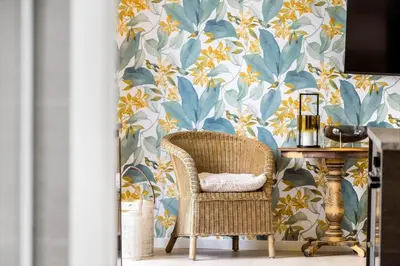 a wicker chair in front of a wall with a floral wallpaper at 193-Vestervig-Vesterhavsvej-36 in Vestervig