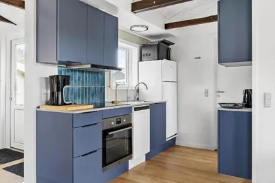a kitchen with blue cabinets and white appliances at 149-Snedsted-Lykkens-Hab-39 in Snedsted