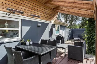 a patio with a wooden table and chairs on a deck at 704-Thisted-Kristinesvej-54 in Thisted