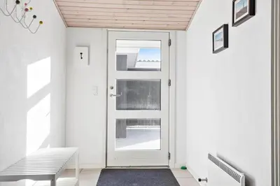 a white door in a hallway with a bench at 475-Thisted-Muslingevej-5 in Thisted