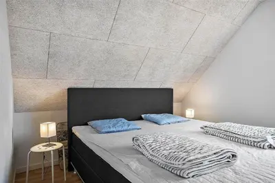 a bedroom with a large bed with blue pillows at 803-Thisted-Hummervej-3 in Thisted