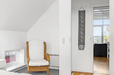 a white room with a chair and a fireplace at 541-Thisted-Nordsovej-49 in Thisted