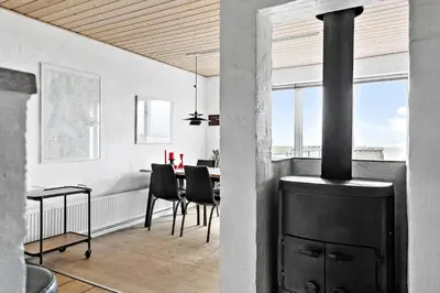 a dining room with a fireplace and a dining table at 264-Vestervig-Krik-Strandvej-20 in Vestervig