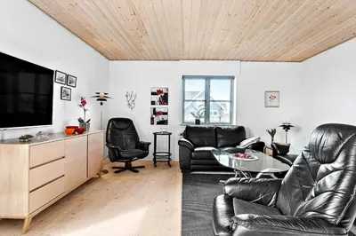 a living room with black leather furniture and a flat screen tv at 264-Vestervig-Krik-Strandvej-20 in Vestervig