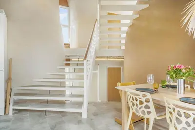 a staircase in a living room with a table and chairs at 302-Snedsted-Klitfogedvej-7 in Snedsted