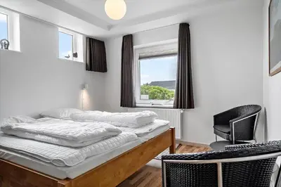 a bedroom with a bed and a chair and a window at 303-Thisted-Hotelvej-5-F in Thisted