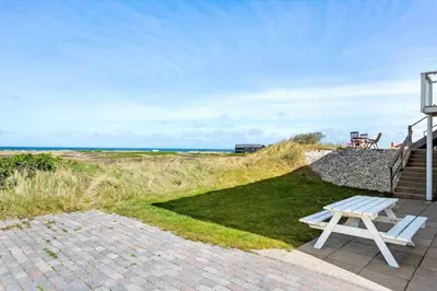 a white picnic table sitting on a patio near the ocean at 303-Thisted-Hotelvej-5-F in Thisted