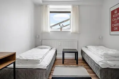 two beds in a room with a window and a table at 303-Thisted-Hotelvej-5-F in Thisted