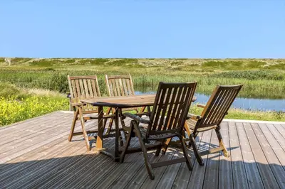 three chairs and a wooden table on a deck at 394-Vestervig-Magevej-43 in Vestervig
