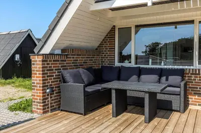 a patio with a couch and a table on a deck at 394-Vestervig-Magevej-43 in Vestervig