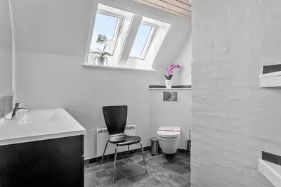 a bathroom with a chair and a sink and a toilet at 394-Vestervig-Magevej-43 in Vestervig