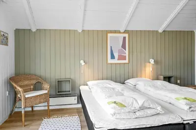 a bedroom with two beds and a chair at 620-Thisted-Pighvarvej-20 in Thisted