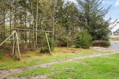 a swing set in the grass next to a body of water at 621-Thisted-Molgaardsvej-21 in Thisted
