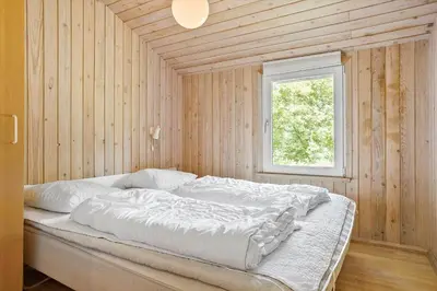 a bed in a wooden room with a window at 466-Thisted-Muslingevej-6 in Thisted