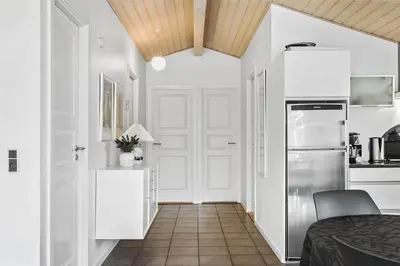 a white kitchen with a refrigerator and a table at 433-Thisted-Tunvej-20 in Thisted