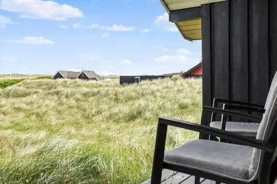 a chair on the porch of a house with a field of grass at 915-Thisted-P-Bolesens-Vej-11 in Torsted