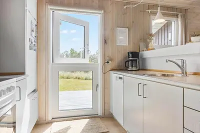 a kitchen with white cabinets and a door with a window at 211-Vestervig-Rylevej-1 in Vestervig