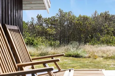 two wooden chairs sitting on the porch of a house at 211-Vestervig-Rylevej-1 in Vestervig