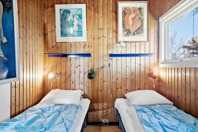 two beds in a room with wooden walls at 340-Thisted-Delfinvej-25 in Thisted