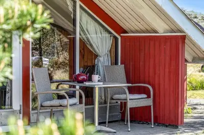 a table and chairs on a patio with a red shed at 340-Thisted-Delfinvej-25 in Thisted