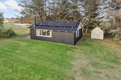 a black house with a solar roof on a grass field at 114-Thisted-Tunvej-14 in Thisted