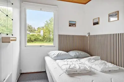 a bedroom with a bed with two pillows and a window at 140-Vestervig-Bekkasinvej-14 in Vestervig