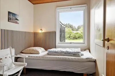 a small bedroom with a bed and a window at 140-Vestervig-Bekkasinvej-14 in Vestervig