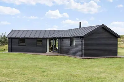 a black house on a field with a grass yard at 939-Thisted-Niels-Vognmands-Vej-3 in Torsted