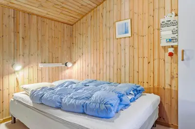 a bed in a room with a wooden wall at 318-Thisted-Nordsovej-204-A in Thisted