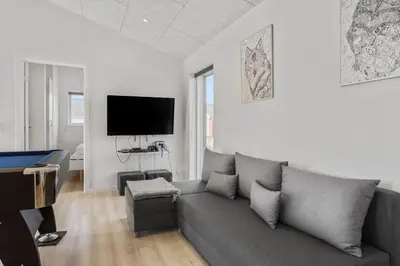 a living room with a gray couch and a flat screen tv at 105-Thisted-Gronkaervej-19-B in Thisted