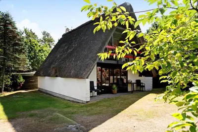 a building with a roof with a table and chairs at 216-Snedsted-Grahavrevej-6 in Snedsted