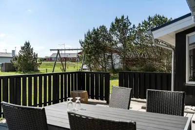 a patio with a table and chairs on a fence at 534-Thisted-Fiskervej-123 in Thisted